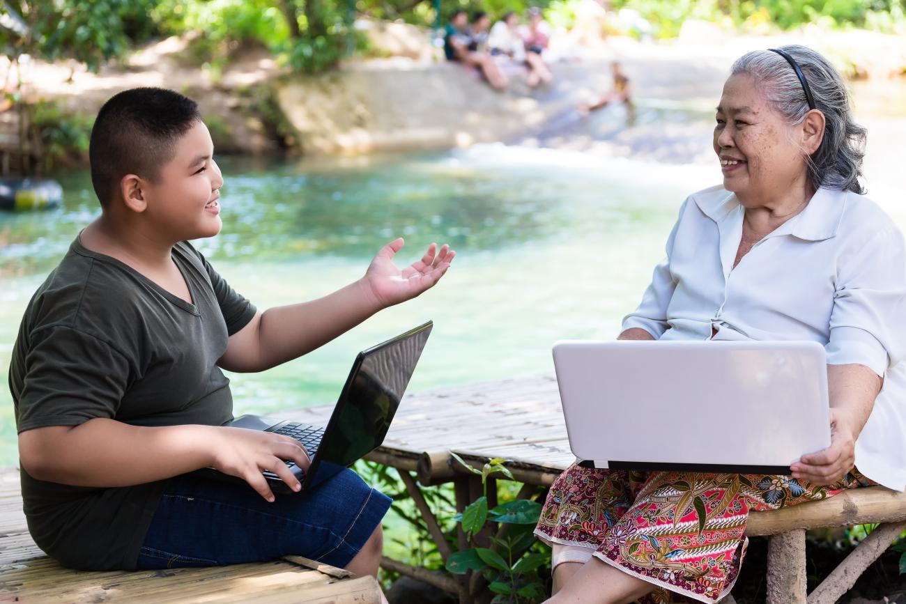 grandson-teaching-his-elderly-female-use-laptop